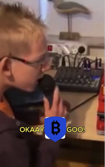 A young boy excitedly shouts into a microphone while shouting "OKAAAY GOO!" beside a Bitcoin logo, humorously representing BitGo's "go" announcement. The image playfully celebrates BitGo (NYSE: BTGO) migrating over $7.7 billion in Wrapped Bitcoin (WBTC) to Chainlink CCIP as its exclusive cross-chain infrastructure.
