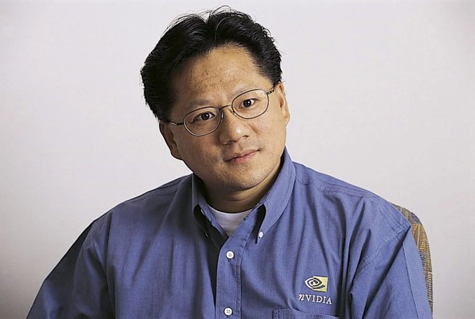 A middle-aged man wearing glasses and a blue NVIDIA-branded button-up shirt poses for a portrait against a neutral background. The accompanying post highlights the NVIDIA logo on his shirt, celebrating the company's success and long-term belief in its visionary leadership.