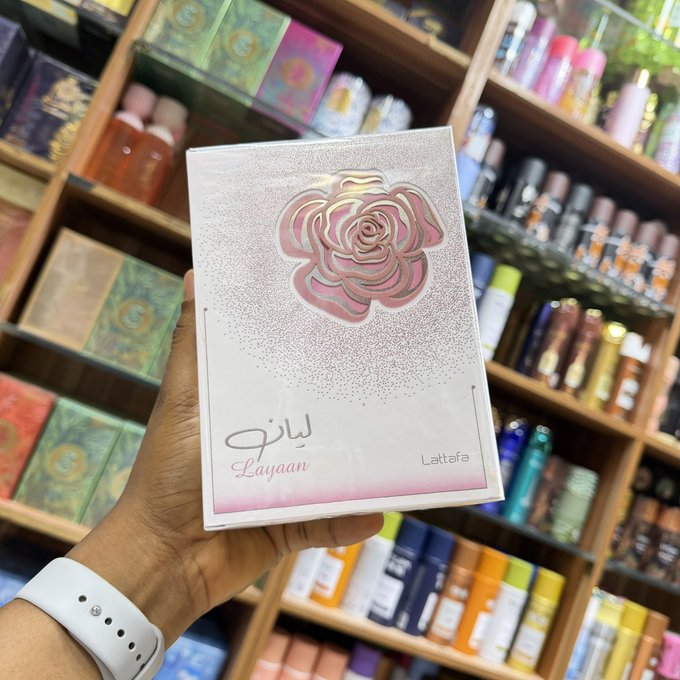 The image shows a hand holding a pink "Layaan Lattafa" perfume box, displayed in front of wooden shelves stocked with various fragrances. The image does not visually relate to the post's discussion of onchain loan rates, TermMaxFi, or Miden—instead, the caption seems to highlight the irony of a product clearly labeled with a price, contrasting with the post's point about unpredictability in decentralized finance.