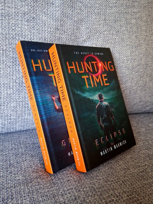 Two copies of the book "HUNTING TIME: ECLIPSE" by Martin Warwick lean against a textured grey surface.