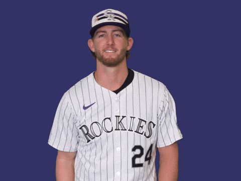 The image features a baseball player wearing a white and black striped jersey with the number 24 standing against a blue background. The player appears to be posing for a photo, possibly for a sports team's promotional material or social media posts.