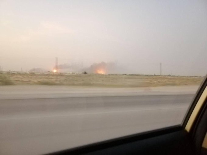 Flames and smoke are erupting from an industrial area in the distance, likely causing the exclamation "Oh shietttt."