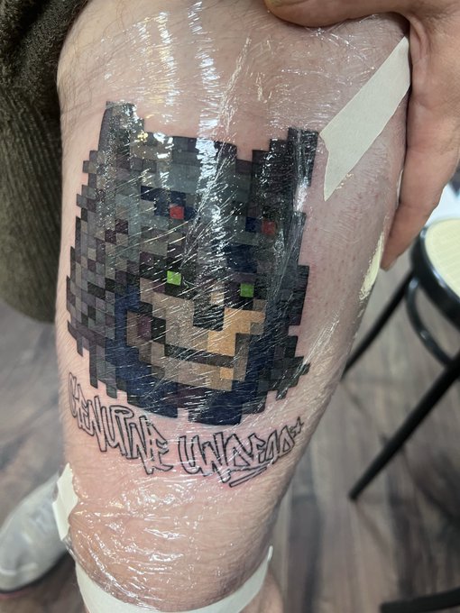 A fresh pixel-art tattoo of a black panther with the text "NOVA PATNA UNIVERZITAS" is shown wrapped in protective plastic wrap, with the post "Done" indicating the tattoo session has just been completed.