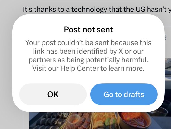 A screenshot of an X (formerly Twitter) error message reading "Post not sent - Your post couldn't be sent because this link has been identified by X or our partners as being potentially harmful," with "OK" and "Go to drafts" buttons. The user is posting about their "papertrade" domain being link-blocked despite scams running rampant on the platform.