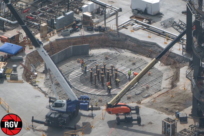 An aerial view of a construction site shows workers and cranes building a circular foundation with a rebar grid, featuring an 'RGV' logo in the bottom left corner.