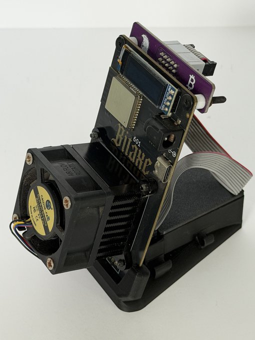 A DIY electronics project housed in a black 3D-printed case featuring a small OLED display, a speaker, and a circuit board labeled "Blaze 60X" connected by a ribbon cable.