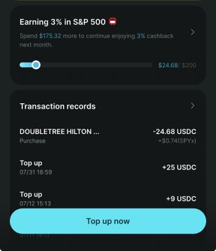 A cryptocurrency rewards app screen showing 'Earning 3% in S&P 500' cashback status, transaction records including a Doubletree Hilton purchase of -24.68 USDC, and a 'Top up now' button.