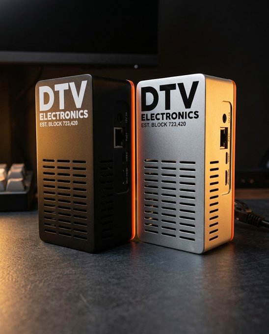 Two DTV Electronics (EST. BLOCK 723,420) devices—one black and one silver—shown side by side with orange accent lighting on a desk.