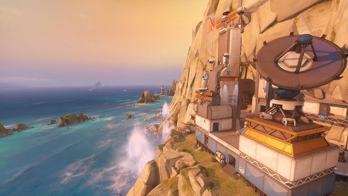 A scenic digital artwork or video game environment showing a coastal cliffside base with industrial buildings, satellite dishes, and ocean views at sunset.