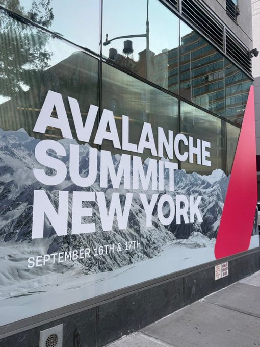 A street-side advertisement on a glass window for "AVALANCHE SUMMIT NEW YORK" scheduled for "SEPTEMBER 16TH & 17TH," featuring a snowy mountain landscape.