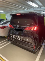 A black Toyota minivan parked in a garage, featuring custom 'KKAST V.I.P.' lettering on its rear bumper.