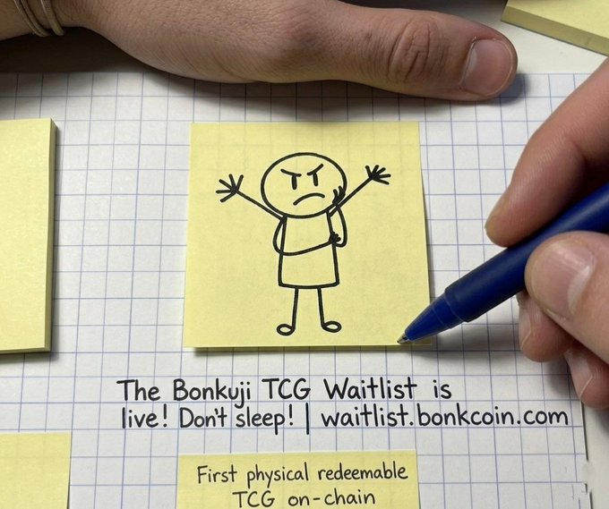 The image shows a person's hand holding a blue pen over a piece of paper with a cartoon character drawing, possibly a cartoon person or a stick figure, on it. The text "The Bonkuji TCG Waitlist is live! Don't sleep/": (first physical redeemable) @bonk_inu WaitList: waitlist bonkcoin.com" is also present in the image. This suggests that there might be an online waiting list for a particular cartoon character or a similar collectible item, and the person's hand could be signing up to join this waiting list.
