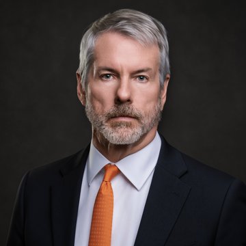 A portrait of a distinguished, gray-haired man in a dark suit with an orange tie, likely representing Michael Saylor, whose company Strategy (MSTR) significantly expanded its Bitcoin holdings by acquiring 4,603 BTC for $369.7 million.