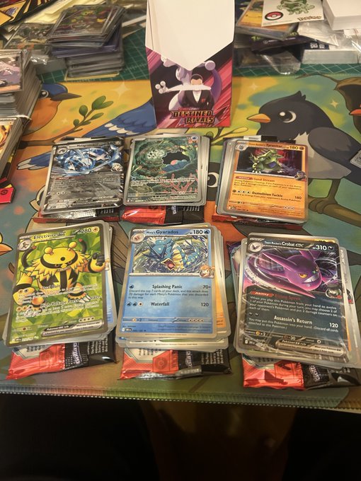 Several stacks of Pokémon trading cards, including Electivire, Gyarados, and Toxtricity, displayed on a table.