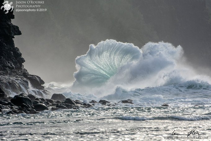 A dramatic photograph of a large wave crashing against rocks by Jason O'Rourke (@jasonorphoto), with watermarks visible including 'JASON O'ROURKE PHOTOGRAPHY ©2019'.