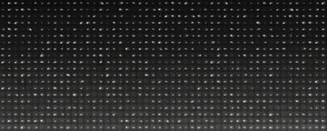 A dark, textured image showing a repeating pattern of small white dots or illuminated points arranged in horizontal rows, resembling a close-up of a mesh, screen, or perforated surface.