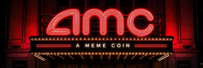 A theater-style marquee with glowing red neon letters spelling 'AMC' and the tagline 'A MEME COIN' below.