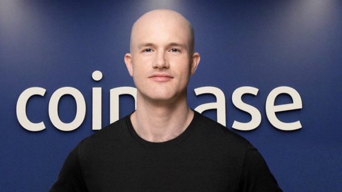 Brian Armstrong, CEO of Coinbase, is pictured in front of the "coinbase" company logo on a blue wall, complementing his bullish statement on Bitcoin as an inflation-resistant store of wealth.