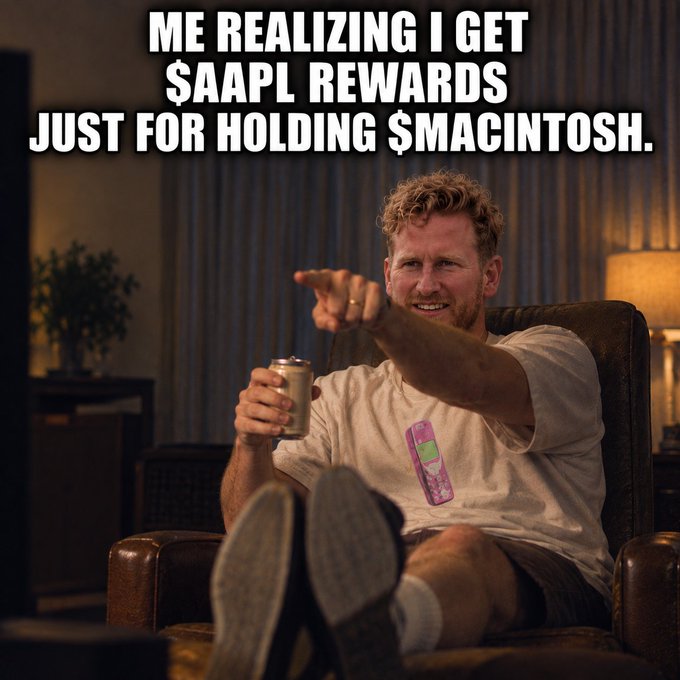 A meme featuring a man sitting in a recliner pointing at the camera with a beer, wearing a shirt with a Game Boy graphic; text reads 'ME REALIZING I GET $AAPL REWARDS JUST FOR HOLDING $MACINTOSH.'