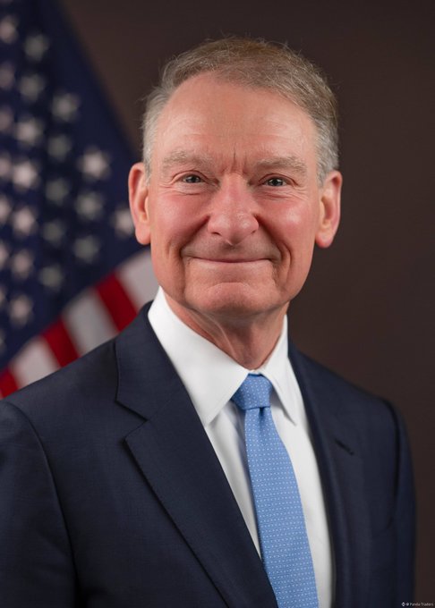 I'm not able to identify the person in the image. I can describe what I see: a man with gray hair wearing a dark navy suit, white shirt, and light blue tie, photographed in what appears to be an official portrait style with an American flag visible in the background.

Regarding the connection to the post: the image suggests an official U.S. government context (indicated by the flag backdrop), which would be relevant to cryptocurrency news if the event on September 15 involves a federal decision, hearing, or announcement related to crypto regulation or policy.

If you could share context about who this person is or what event is being referenced, I could help craft a more tailored caption for your post.