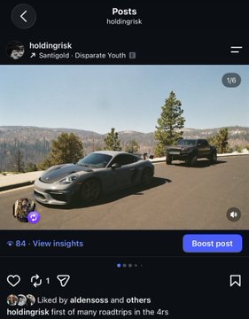 The image is a screenshot of an Instagram post by "holdingrisk" featuring a gray sports car parked at a scenic mountain overlook, with another vehicle and forest visible in the background. The post's caption mentions that the user has "started posting a bit on IG" with plans to create YouTube videos and social media content, noting there aren't many good creators in the space yet, while promoting their handle @HoldingRisk.

This appears to be the very first post on the account, as indicated by the caption's reference to "first of many roadtrips in the 4rs," suggesting this scenic mountain drive content is meant to showcase the type of automotive lifestyle content the creator plans to develop on the platform.