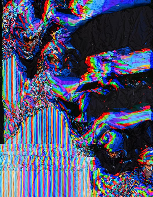 Abstract digital artwork featuring a reclining figure rendered in a vibrant, glitch-like effect with shifting RGB color channels creating a chromatic aberration appearance.