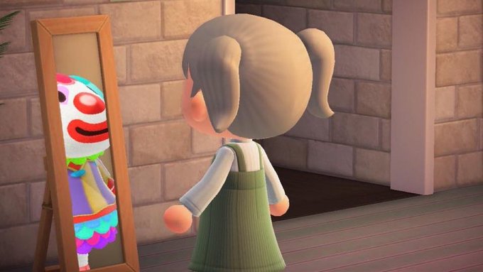A 3D-animated girl with pigtails and a green dress stands facing a mirror, where her reflection appears as a clown with a red nose and colorful outfit.