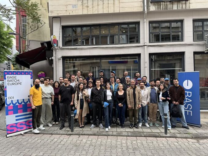 A large group of Base Batch: Europe attendees poses for a photo outside a venue in Istanbul's Kadıköy district, flanked by branded signs reading "BASE BATCH: EUROPE 001" and "BASE." The gathering reflects the Base network's community meetup highlighted in the post, showcasing the developers and community leaders who connected at the event.