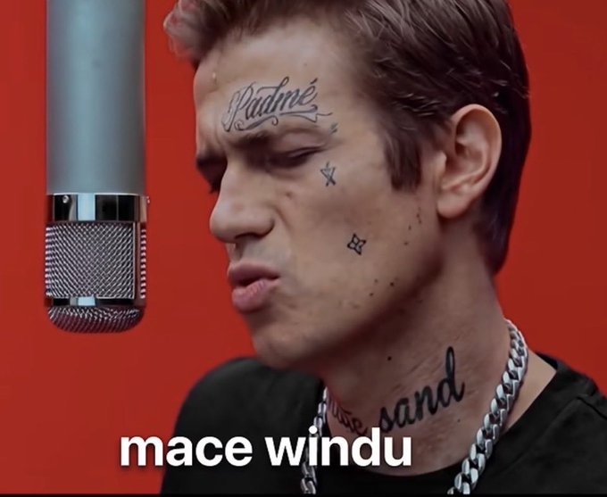 A close-up of a man with facial tattoos including "Padmé" on his forehead sings into a studio microphone, with the caption "mace windu" displayed at the bottom.