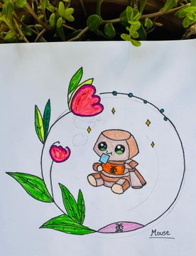 A child's hand-drawn artwork on white paper shows a small animal character (possibly a monkey or bear) inside a circular bubble, decorated with red flowers and green leaves, signed 'Mouse' in the corner, with real greenery visible at the top edge.