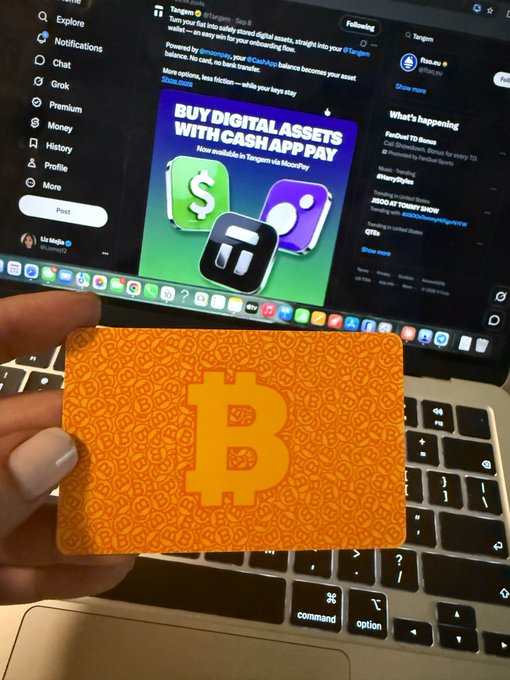 A hand holds an orange Bitcoin card over a laptop keyboard, with the screen displaying a Twitter/X post about 'BUY DIGITAL ASSETS WITH CASH APP PAY' and a promotional graphic for MoonPay.