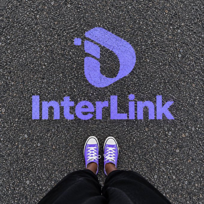 A first-person view shows purple sneakers standing on asphalt beside the purple "InterLink" logo, symbolizing the user's readiness to take their next step into the project. The image visually reinforces the post's call to "Build with InterLink" and "DYOR" with hashtags #InterLink #ITL #ITLG, as the shoes face the logo as if preparing to step forward into the platform.