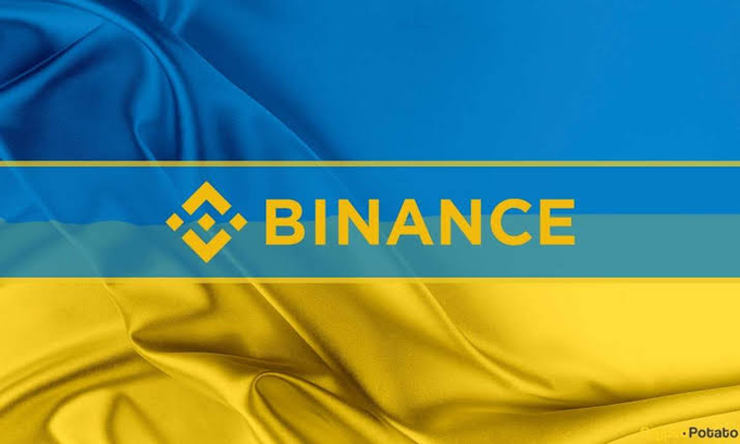 A silk-textured blue and yellow flag with the Binance logo and the word "BINANCE" in gold lettering across the center.