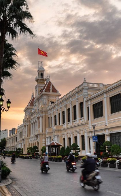 The image shows the People's Committee Building in Ho Chi Minh City, Vietnam, with its iconic yellow French colonial facade, central clock tower, and Vietnamese flag flying at sunset, as motorbikes pass along the street in front. The accompanying post about quantum-resistant crypto doesn't directly relate to the image, though the visible "Ho Chi Minh City" sign hints at Vietnam's growing tech and crypto landscape where such innovations might apply.
