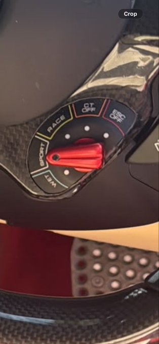 A close-up of a motorcycle dashboard mode selector switch showing options "WET," "SPORT," "RACE," "GT," and "ESC OFF" with a red lever pointing toward "SPORT." The image captures the moment of choosing a riding mode before setting off, tying into the caption's sense of anticipation and preparation.