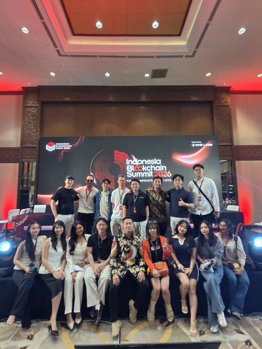 A group photo of attendees posing in front of a backdrop reading 'Indonesia Blockchain Summit 2026' and 'ONE LABS'.