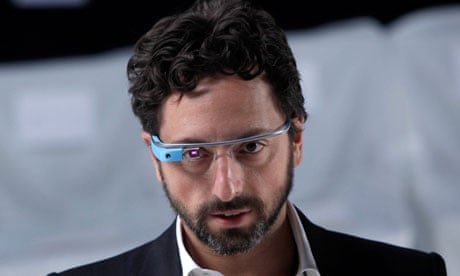 A bearded man with dark curly hair wears blue-rimmed smart glasses (Google Glass) and a dark suit jacket, captured in a close-up shot with a serious, focused expression. The image visually echoes the post's message of intense focus and being "locked in," with his determined gaze and high-tech eyewear reinforcing the "founder mode" vibe of concentration and strategic thinking.