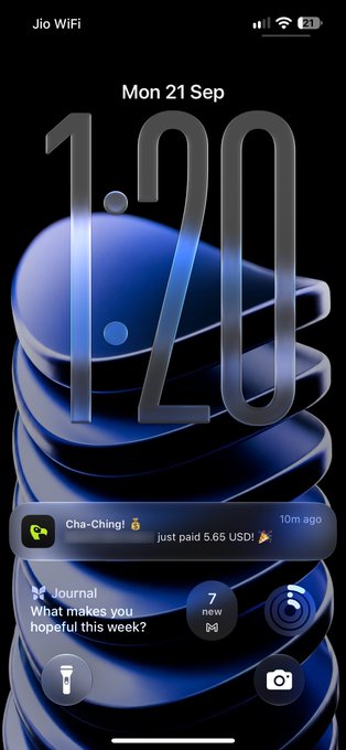 An iPhone lock screen showing 1:20 on Monday, 21 September with a blue stacked 3D wallpaper, displaying a Cha-Ching notification of a $5.65 USD payment and a Journal prompt 'What makes you hopeful this week?'.