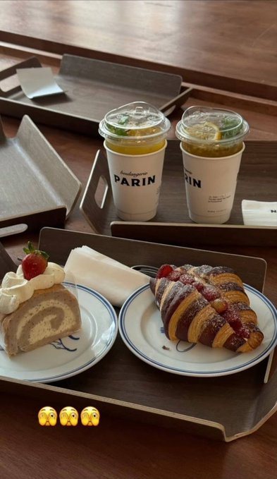 An overhead shot of a cafe table featuring two lemonades branded with 'PARIN', a strawberry roll cake, a strawberry croissant, and lemon meringue on plates, with praying hand emojis overlaid.