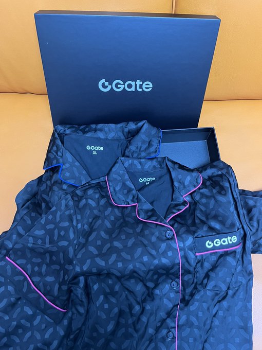 Two dark blue pajamas with pink trim and a leaf pattern are displayed in front of a 'Gate' branded box, one marked 'XL' and the other 'M'.