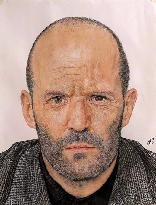 A highly detailed colored pencil or pastel portrait drawing shows a bald, middle-aged man with a serious expression and stubble, wearing a gray houndstooth jacket over a dark shirt.