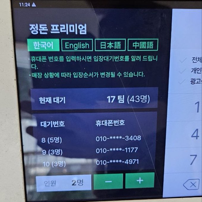 A digital kiosk screen at what appears to be The Hyundai Seoul displays the "정돈 프리미엄" (Jeongdon Premium) waiting list system with language options in Korean, English, Japanese, and Chinese, showing a current wait of 17 teams (43 people) with phone numbers listed for positions 8, 9, and 10, requiring 2 people to join. The image humorously illustrates the long wait time at a popular restaurant, contrasting with the caption's description of a quick, enjoyable tonkatsu meal shared with a business contact at the mall.
