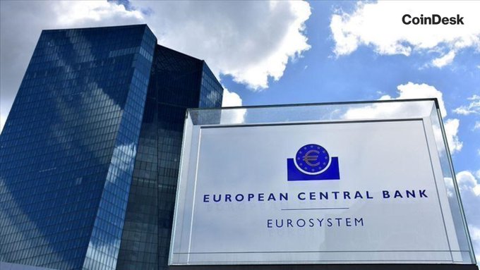 The image shows a sign for the "European Central Bank Eurosystem" with the euro symbol, set against a backdrop of modern skyscrapers and a blue sky. This relates to the post as the ECB has selected 36 payment providers, including Deutsche Bank, UniCredit, and Revolut, for a digital euro pilot launching in H2 2027.