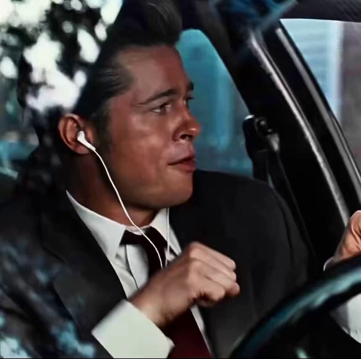 Leonardo DiCaprio, dressed in a sharp suit with white earbuds in, drives a car and smirks knowingly out the window—capturing the smug confidence of $NOW bulls eager to buy the dip in the $80s again.