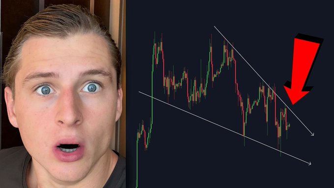 A man with a shocked expression looks at a Bitcoin price chart showing a descending triangle pattern with a large red arrow pointing downward, highlighting a potential breakdown. The caption's claim of an upcoming explosion contrasts humorously with the bearish technical pattern shown in the chart.