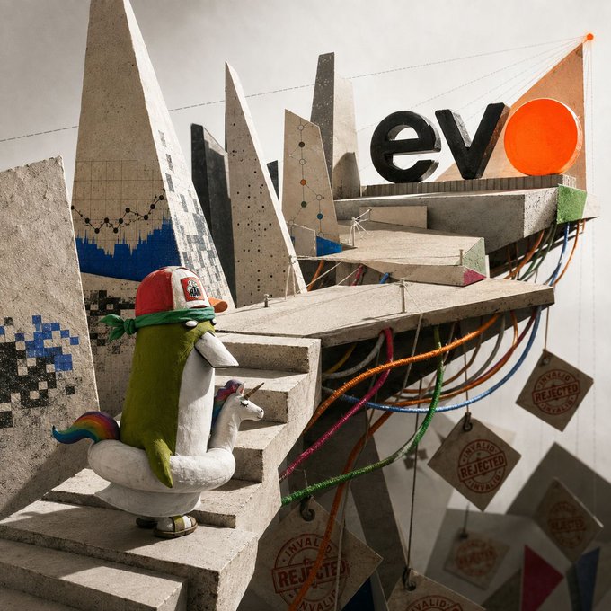 A whimsical 3D-rendered scene features a stuffed duck-unicorn hybrid wearing a red cap and green bandana, sitting on concrete stairs amid a chaotic structure of shattered geometric shapes, tangled colorful cables, and "INVALID/REJECTED" stamps, with the "evo" logo and orange circle prominently displayed atop the wreckage. The visual chaos of broken structures and rejected validation stamps metaphorically contrasts with the post's message of strong validation for $EVO, despite early setbacks, while the quirky mascot embodies the unconventional, creative approach of the AI-powered IDE platform.