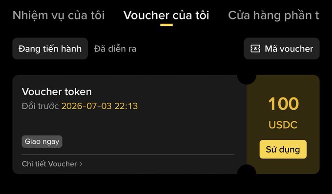 A screenshot of Binance's "Voucher của tôi" (My Vouchers) tab shows a token voucher worth 100 USDC, expiring on 2026-07-03 22:13, with a "Sử dụng" (Use) button available. The image visually supports the post's claim that Binance is distributing a $100 USDC reward, which users can claim through the rewards/voucher section.