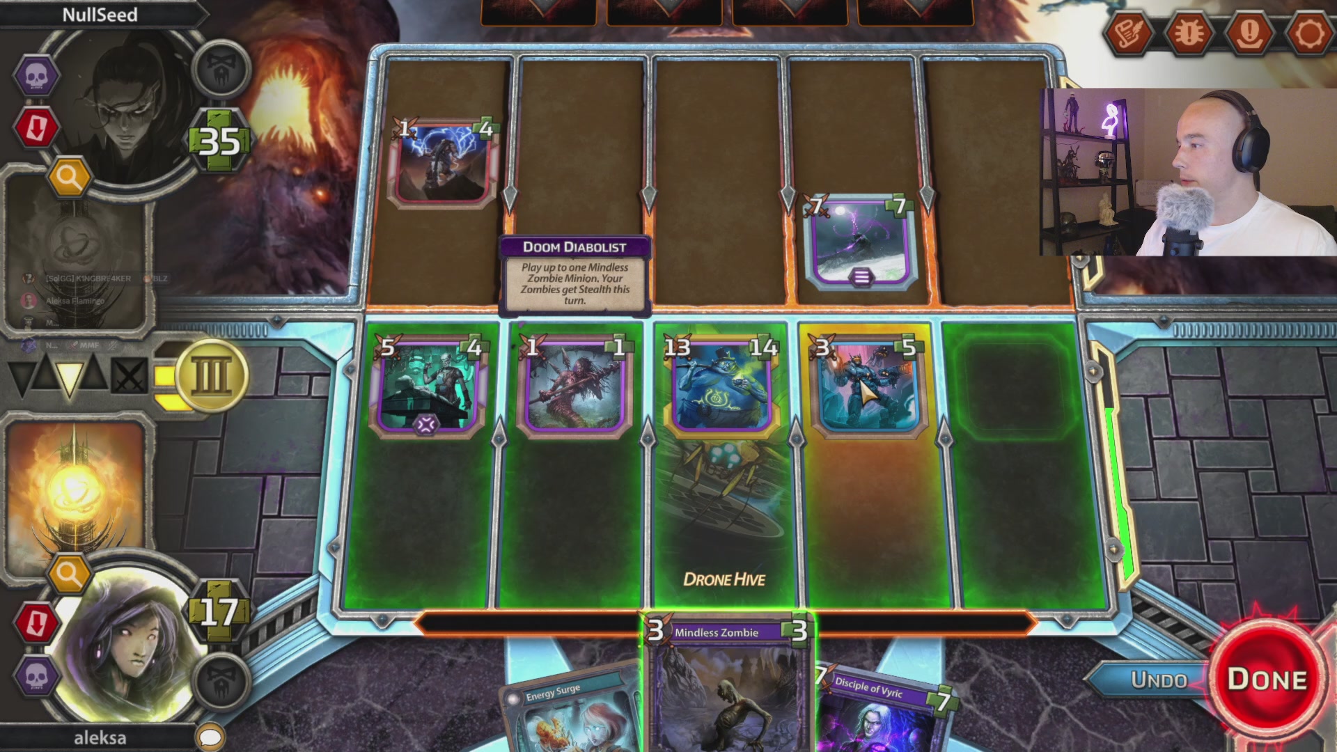 The image shows a video game screen displaying a card game with five cards arranged in two rows of three against a gray background. The player's name, Aleksa Flamingo, can be seen at the bottom left corner of the screen. A caption below the image reads "1 Hour until we are Live! @AleksaFlamingo is streaming with @SolforgeFusion on Solana Gaming building broken combos, fusing decks, and throwing down in PvP." The game appears to be a strategy card game where players must strategically combine their cards to win.
