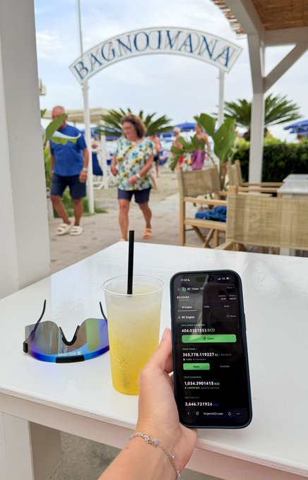 A hand holds a phone displaying "Bagno Ivana" earnings of 1,034.3901415 BC and a refreshing yellow granita sits beside sunglasses at a beach club, perfectly capturing the post's "Granita, sun and $BC staking rewards" theme.