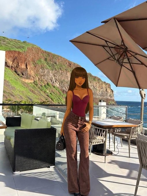 A woman with face obscured by an emoji stands on a scenic cliffside terrace with the ocean and cliffs behind her, wearing a burgundy bodysuit and brown flare pants while holding a small black bag near a patio umbrella and outdoor furniture.